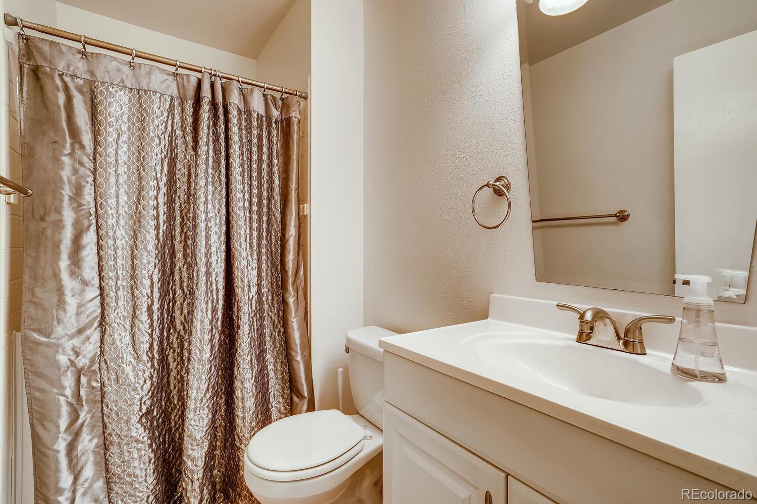 7881 Allison Way, Unit 202 Arvada, CO 80005 - Photo 18 of 26 a bathroom with a sink a toilet and shower curtain