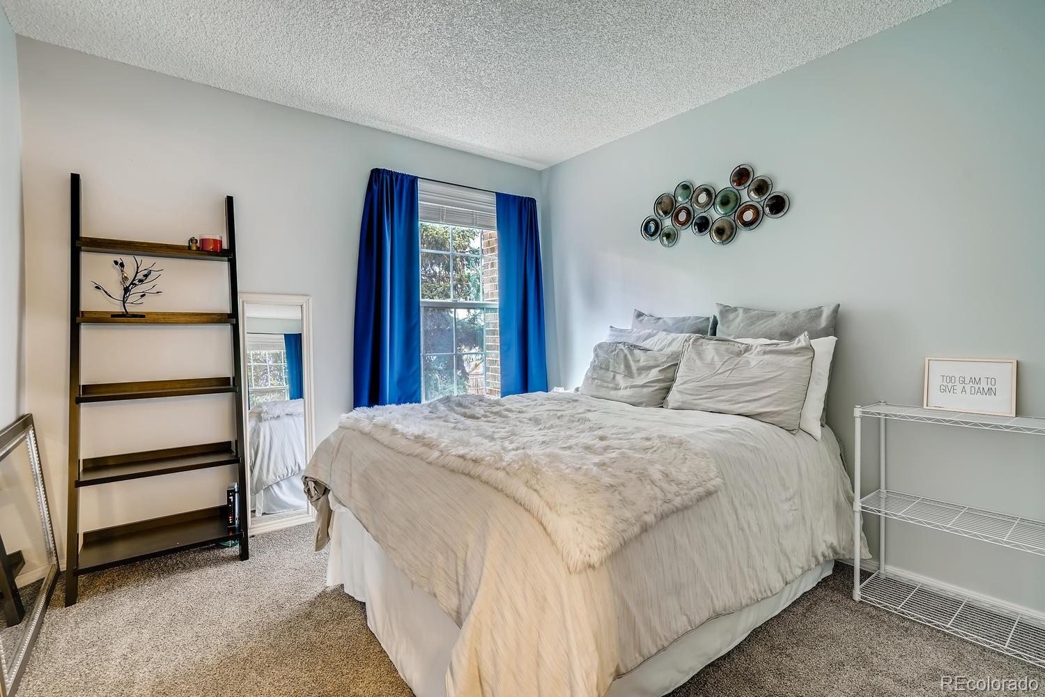7881 Allison Way, Unit 202 Arvada, CO 80005 - Photo 19 of 26 a bedroom with a bed and a chandelier