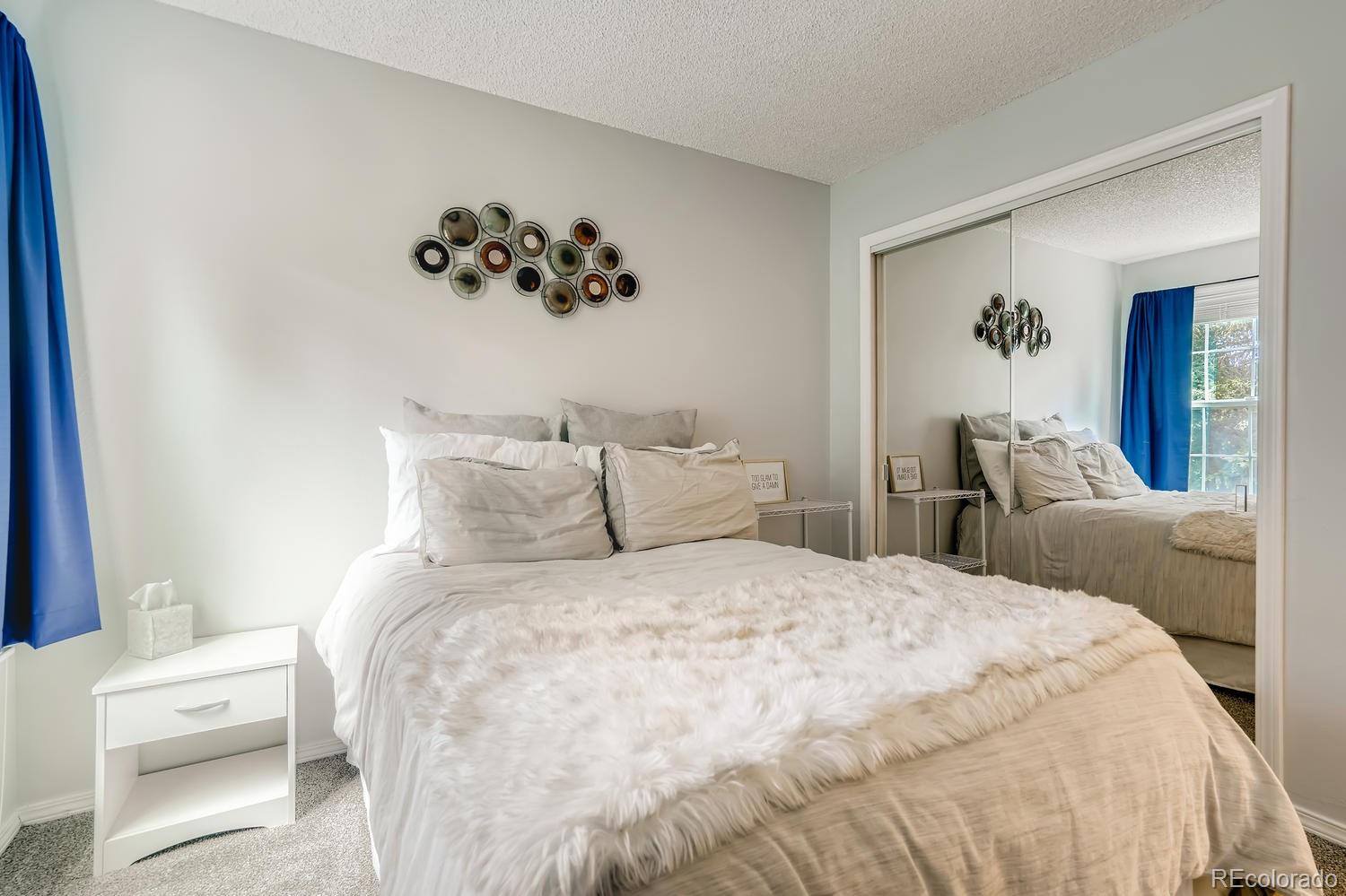 7881 Allison Way, Unit 202 Arvada, CO 80005 - Photo 20 of 26 a bed room with a bed and a painting on the wall