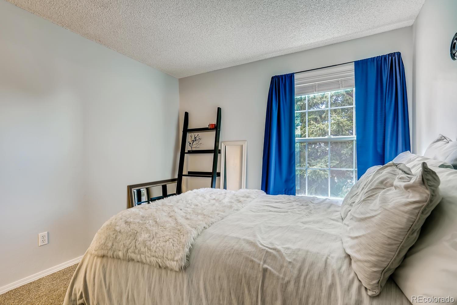 7881 Allison Way, Unit 202 Arvada, CO 80005 - Photo 21 of 26 a bed sitting in a bedroom next to a window