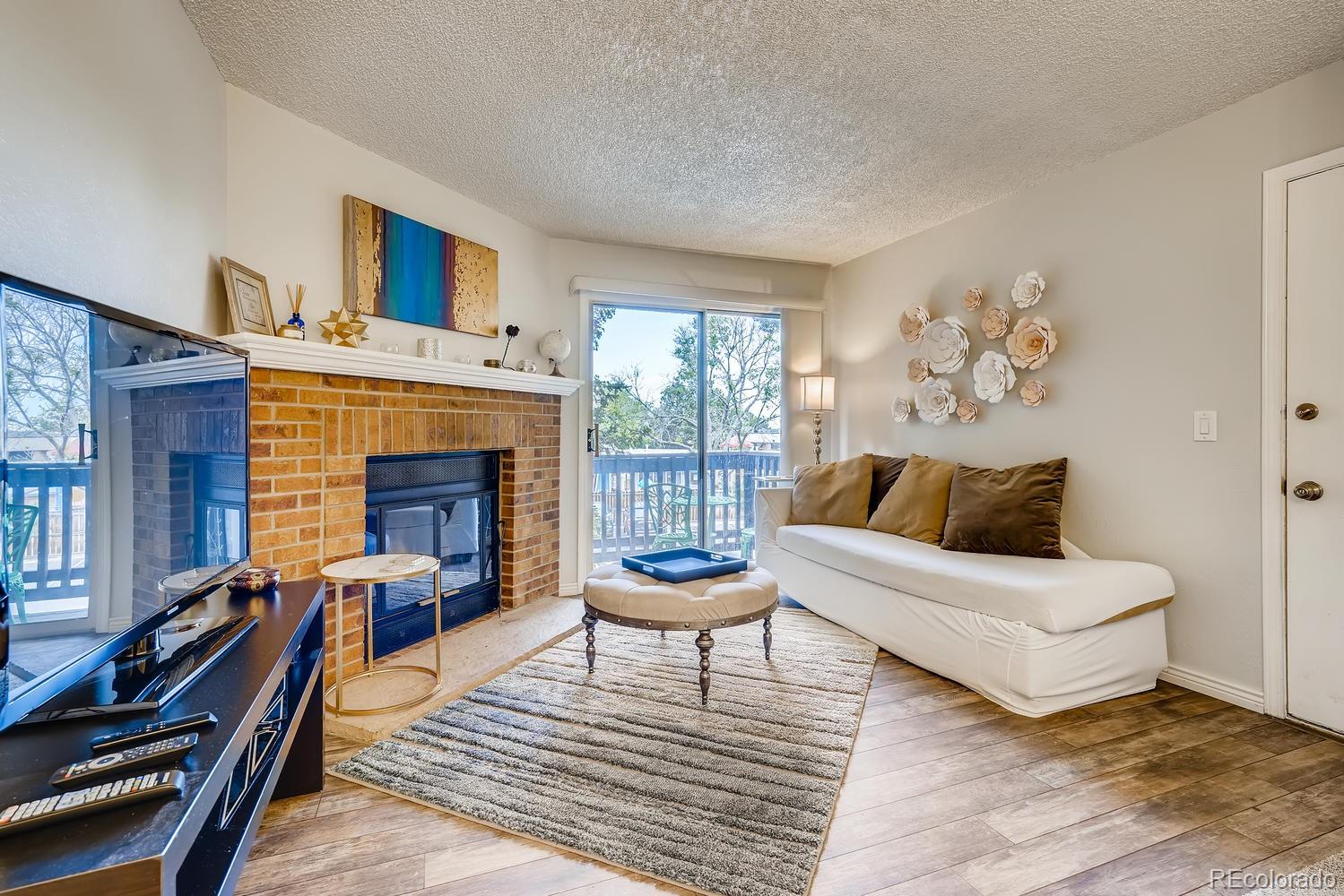 7881 Allison Way, Unit 202 Arvada, CO 80005 - Photo 5 of 26 a living room with furniture and a fireplace