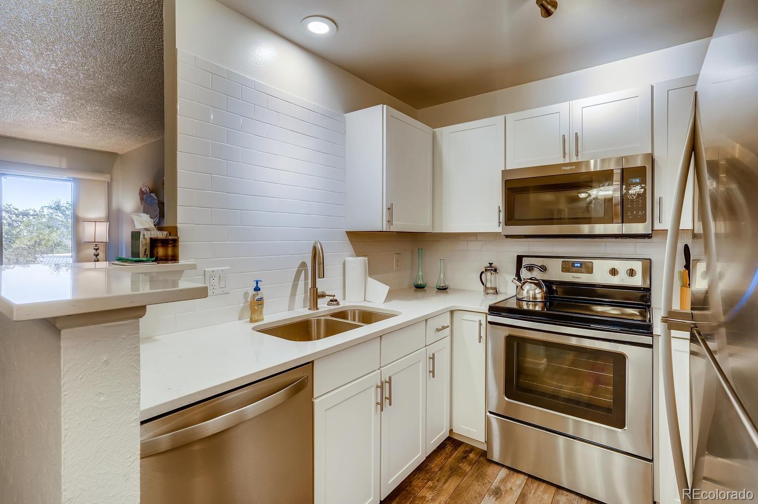 7881 Allison Way, Unit 202 Arvada, CO 80005 - Photo 10 of 26 a kitchen with a sink stove and microwave