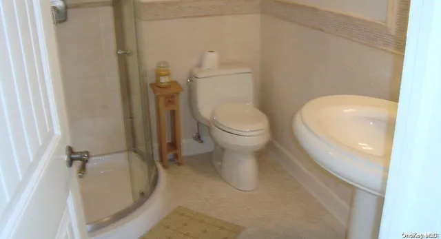 a white toilet sitting next to a shower