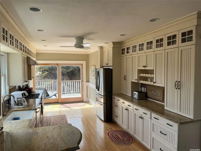 a large kitchen with granite countertop a large window and stainless steel appliances