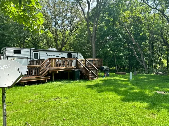 a view of a chair and table on the green field