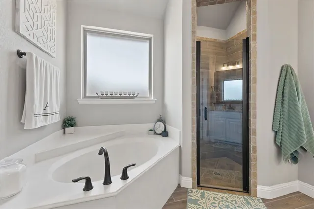 a bathroom with a tub a sink and a window