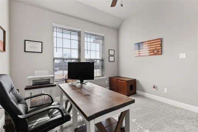 a view of a workspace with furniture and a window