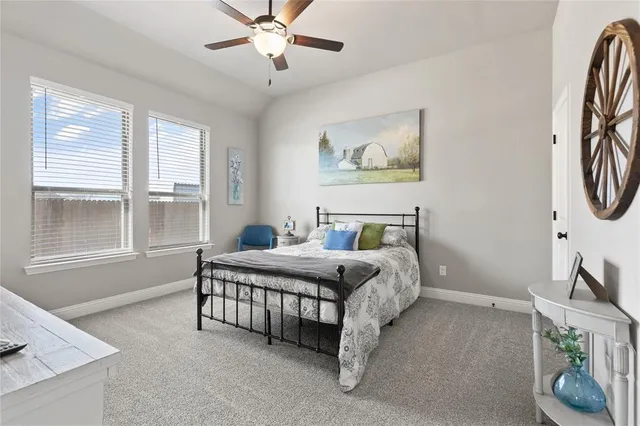 a spacious bedroom with a bed a chandelier and a window
