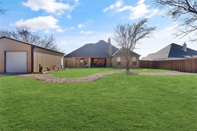 a view of an house with backyard and a tree