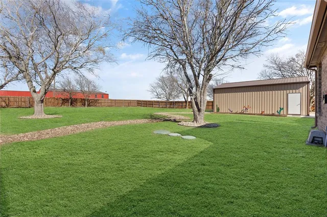 a view of a house with a big yard and large trees