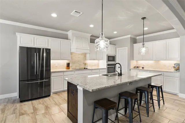 a kitchen with kitchen island granite countertop a sink a center island and stainless steel appliances