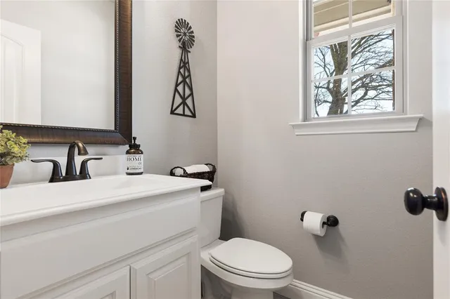 a bathroom with a sink a toilet and a mirror