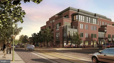 a view of a building and car parked on the side of road