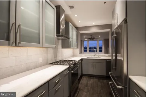 a kitchen with stainless steel appliances granite countertop sink stove and cabinets