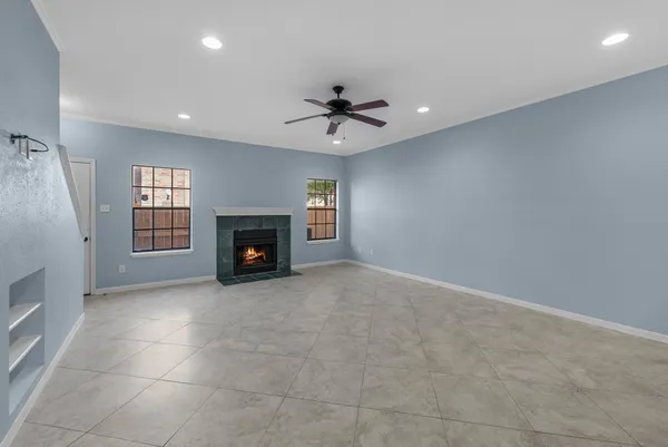 an empty room with windows and fireplace