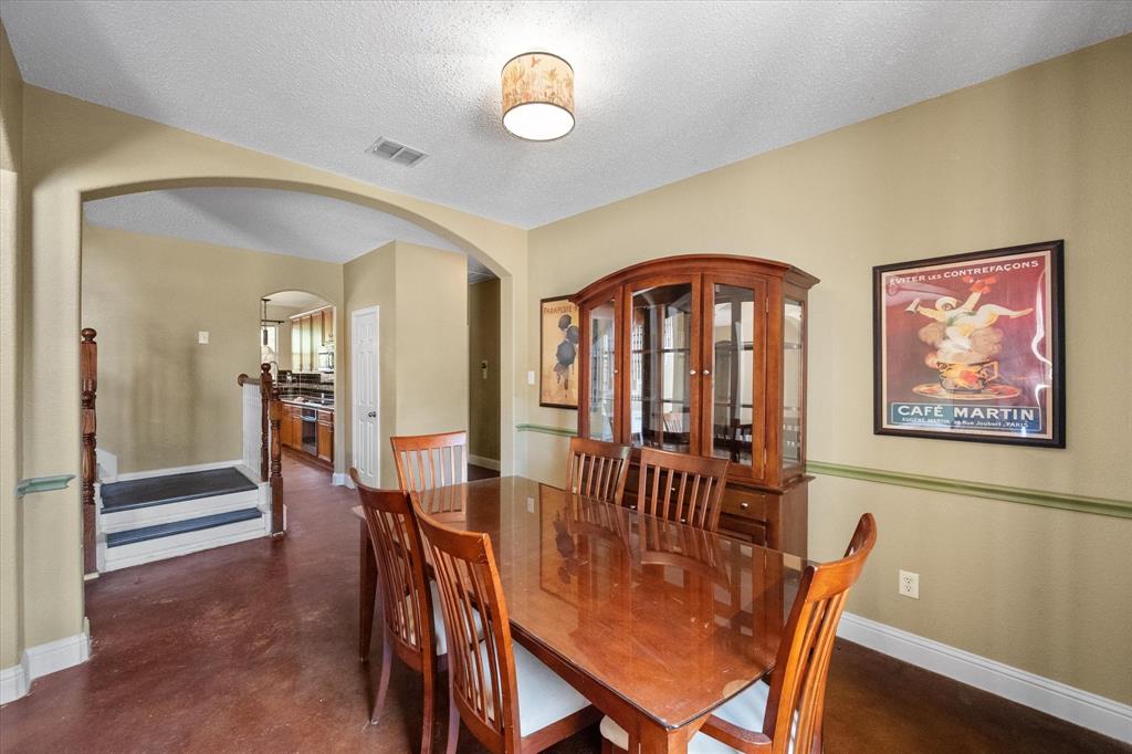 1305 Liverpool Lane Mansfield, TX 76063 - Photo 6 of 40 Dining space featuring a light fixture, neutral-toned walls, and dark flooring