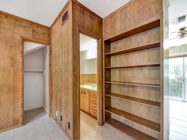 a view of a livingroom with a chandelier fan and windows