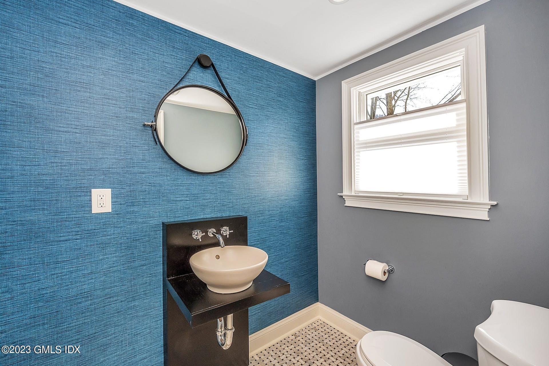 58 Upland Road Stamford, CT 06906 - Photo 14 of 32 a bathroom with a toilet a sink and mirror