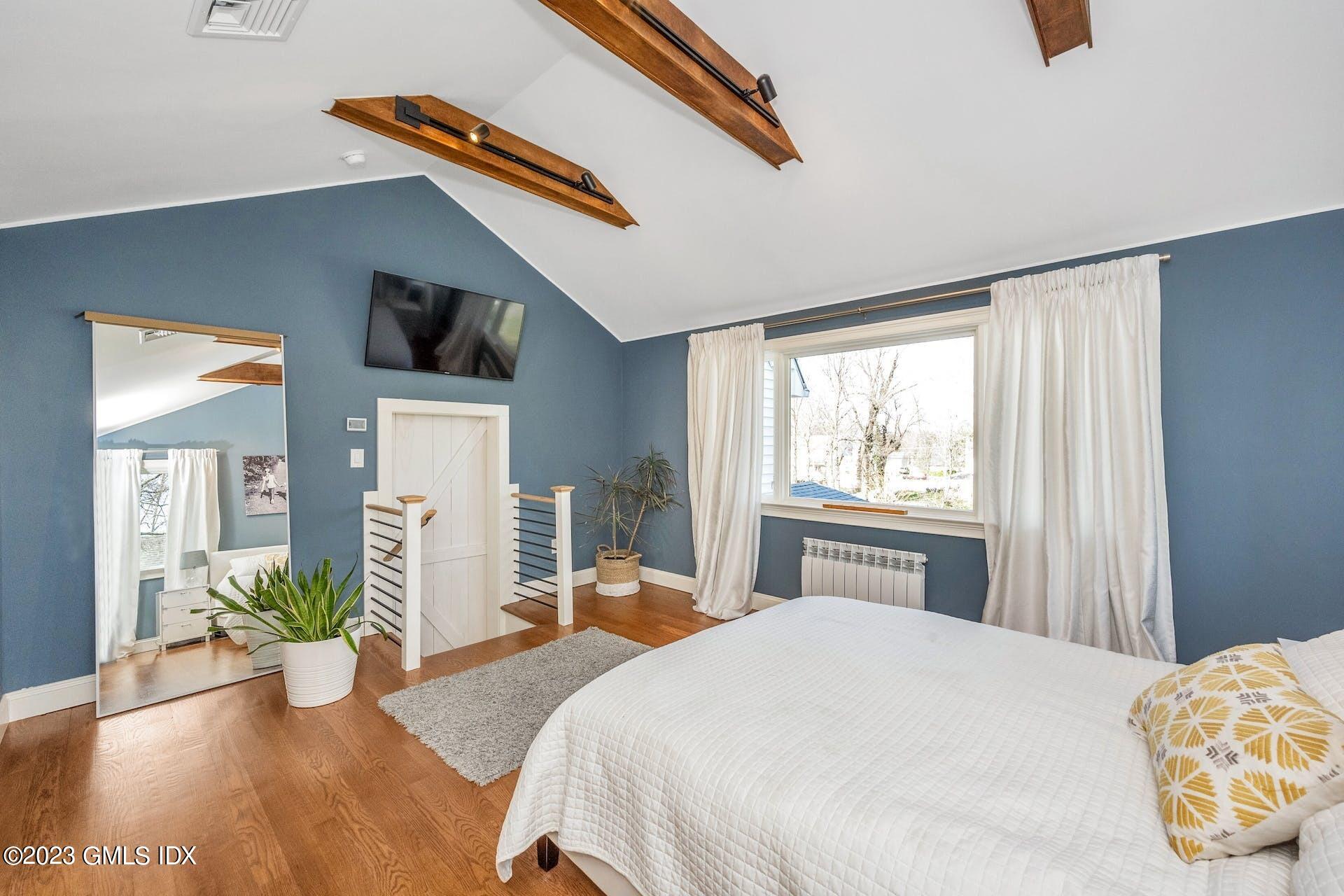 58 Upland Road Stamford, CT 06906 - Photo 15 of 32 a bedroom with a bed and a large window with the outer view