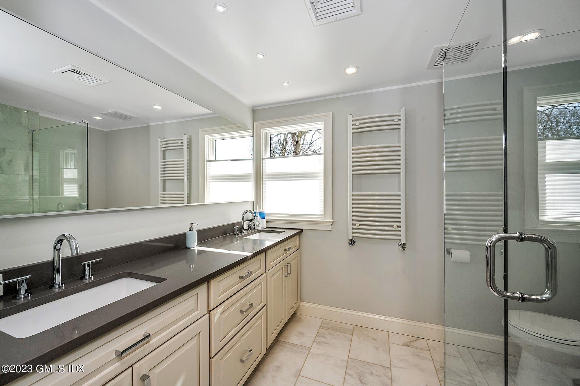 58 Upland Road Stamford, CT 06906 - Photo 19 of 32 a bathroom with double sink and a mirror