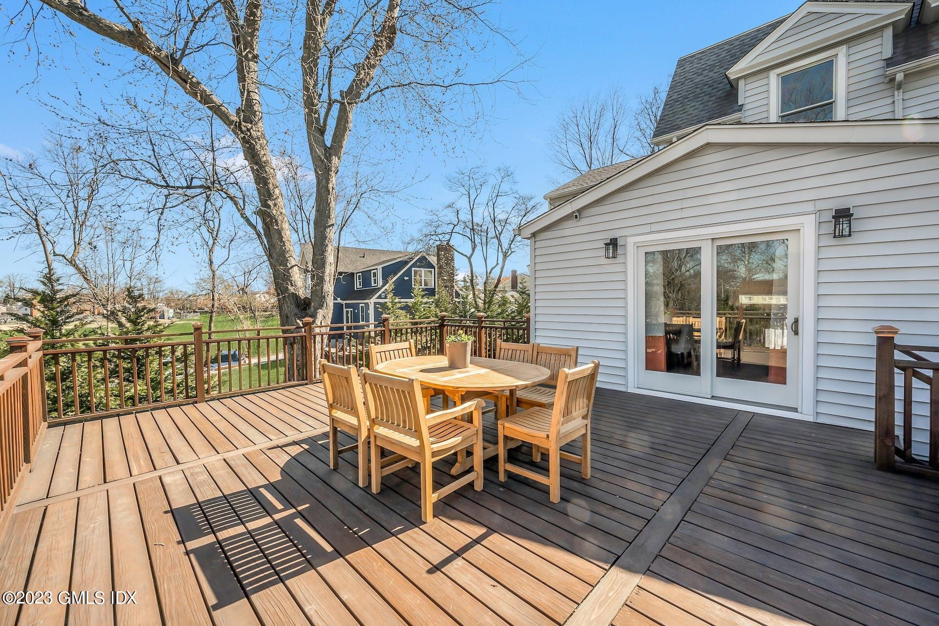 58 Upland Road Stamford, CT 06906 - Photo 27 of 32 a view of a patio with table and chairs and wooden floor