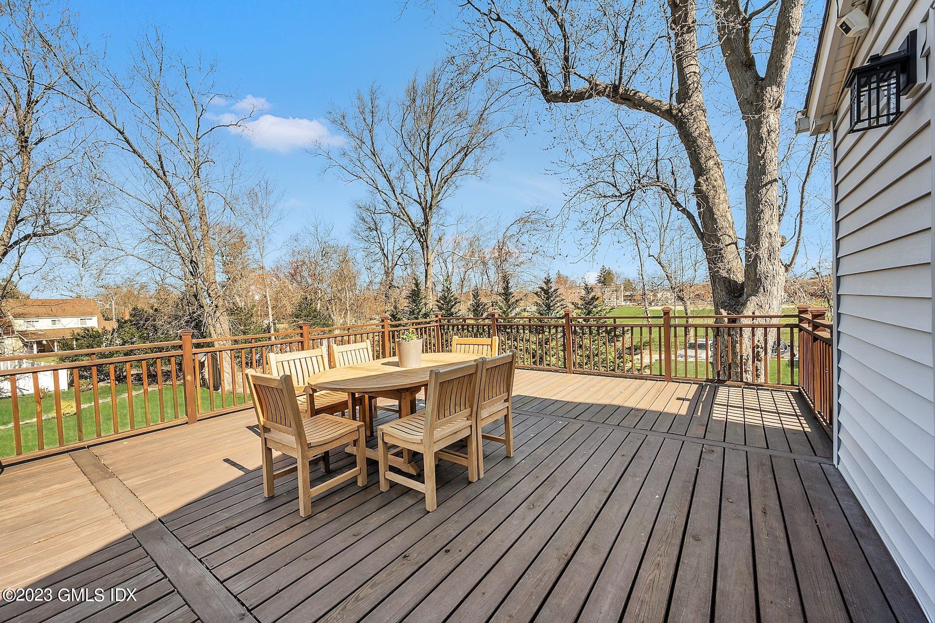 58 Upland Road Stamford, CT 06906 - Photo 28 of 32 a view of a roof deck with table and chairs a barbeque with wooden floor and fence