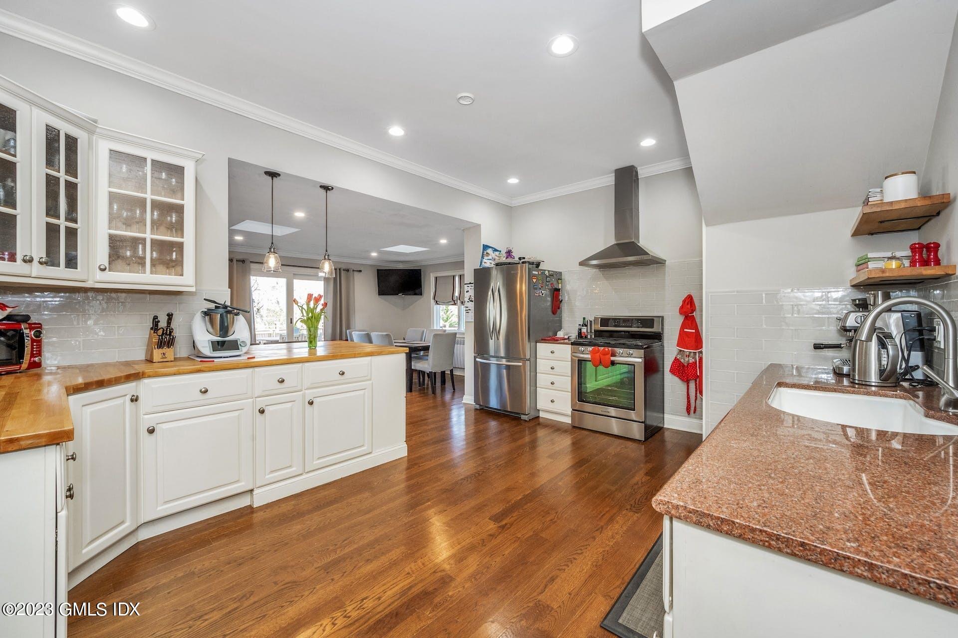 58 Upland Road Stamford, CT 06906 - Photo 7 of 32 a large kitchen with stainless steel appliances granite countertop a lot of counter space and wooden floor