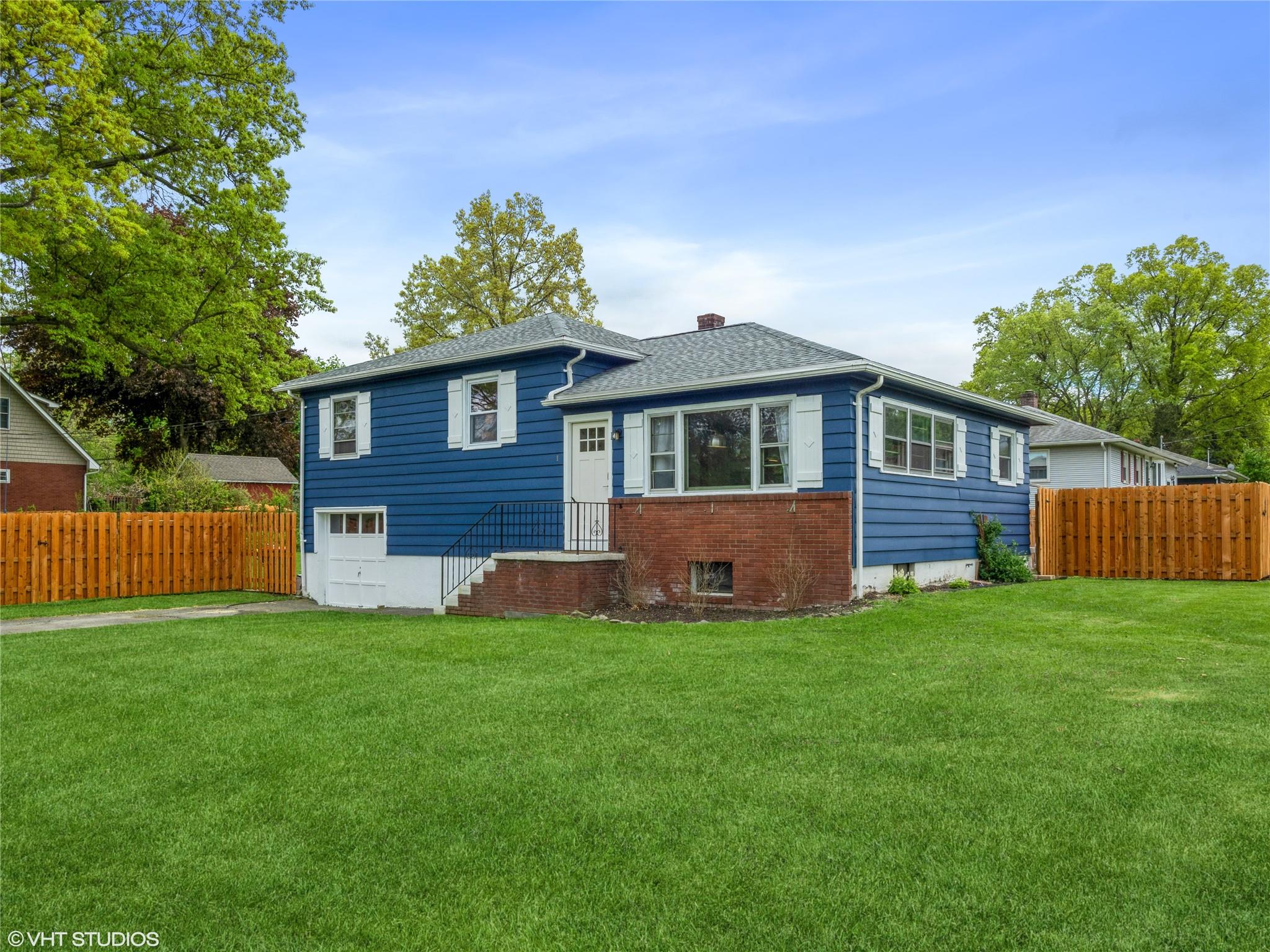 a front view of a house with a yard and trees