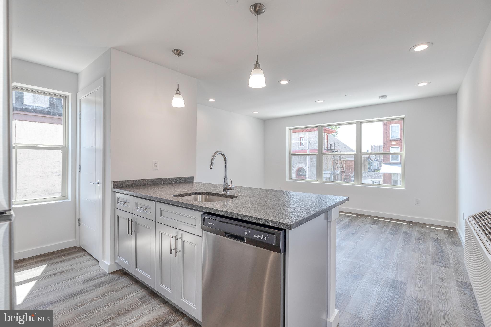 751 North 43rd Street, Unit 302 Philadelphia, PA 19104 - Photo 1 of 17 a kitchen with stainless steel appliances granite countertop a sink a window and wooden floor