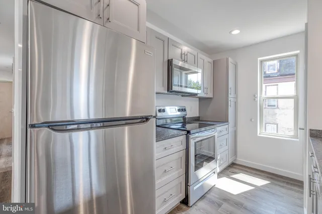 a kitchen with stainless steel appliances a refrigerator sink and cabinets