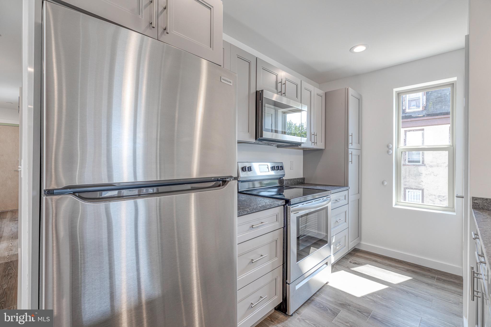 751 North 43rd Street, Unit 302 Philadelphia, PA 19104 - Photo 3 of 17 a kitchen with stainless steel appliances a refrigerator sink and cabinets