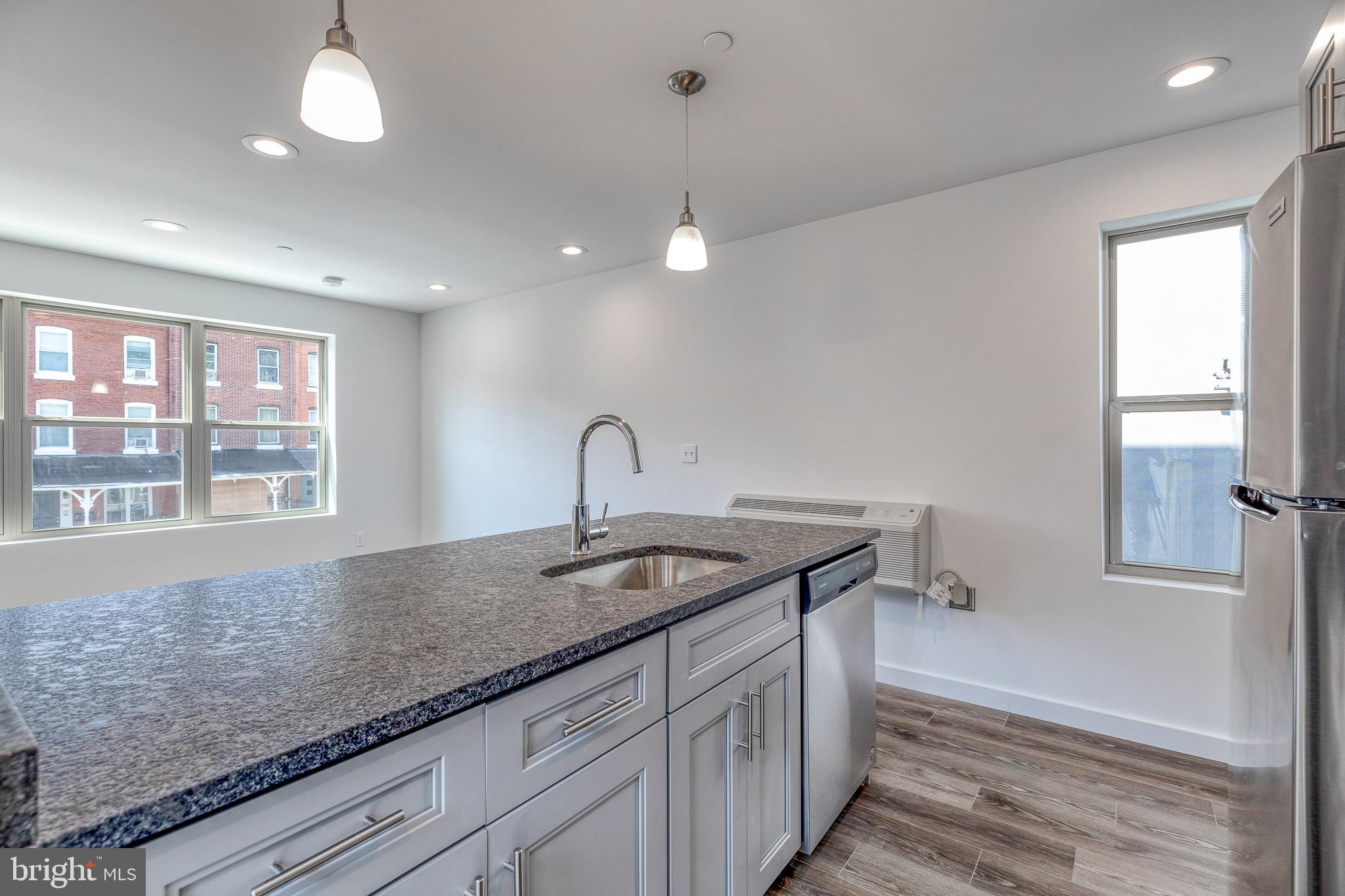 751 North 43rd Street, Unit 302 Philadelphia, PA 19104 - Photo 4 of 17 a kitchen with granite countertop a sink and a window