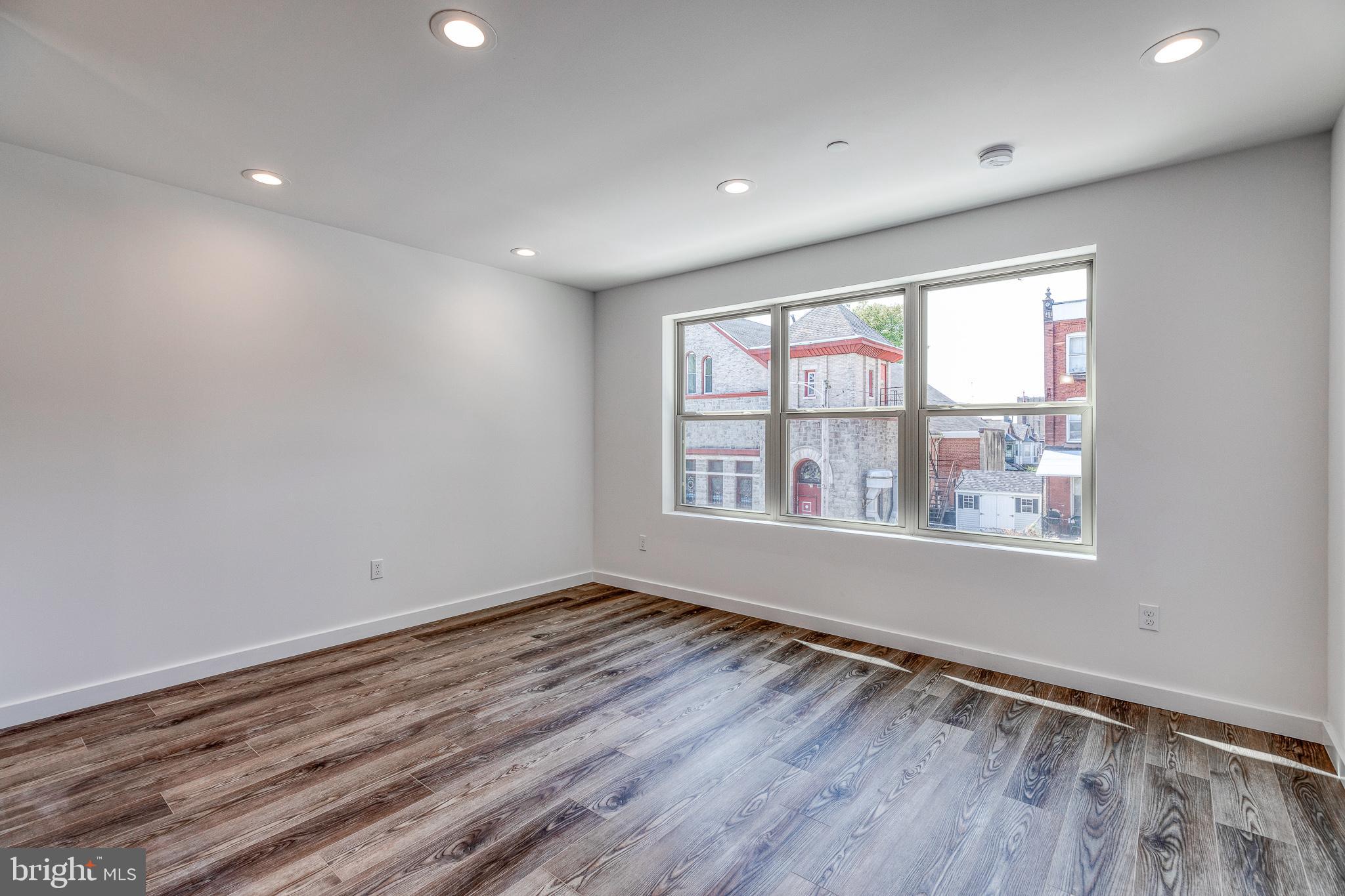 751 North 43rd Street, Unit 302 Philadelphia, PA 19104 - Photo 6 of 17 an empty room with wooden floor and windows