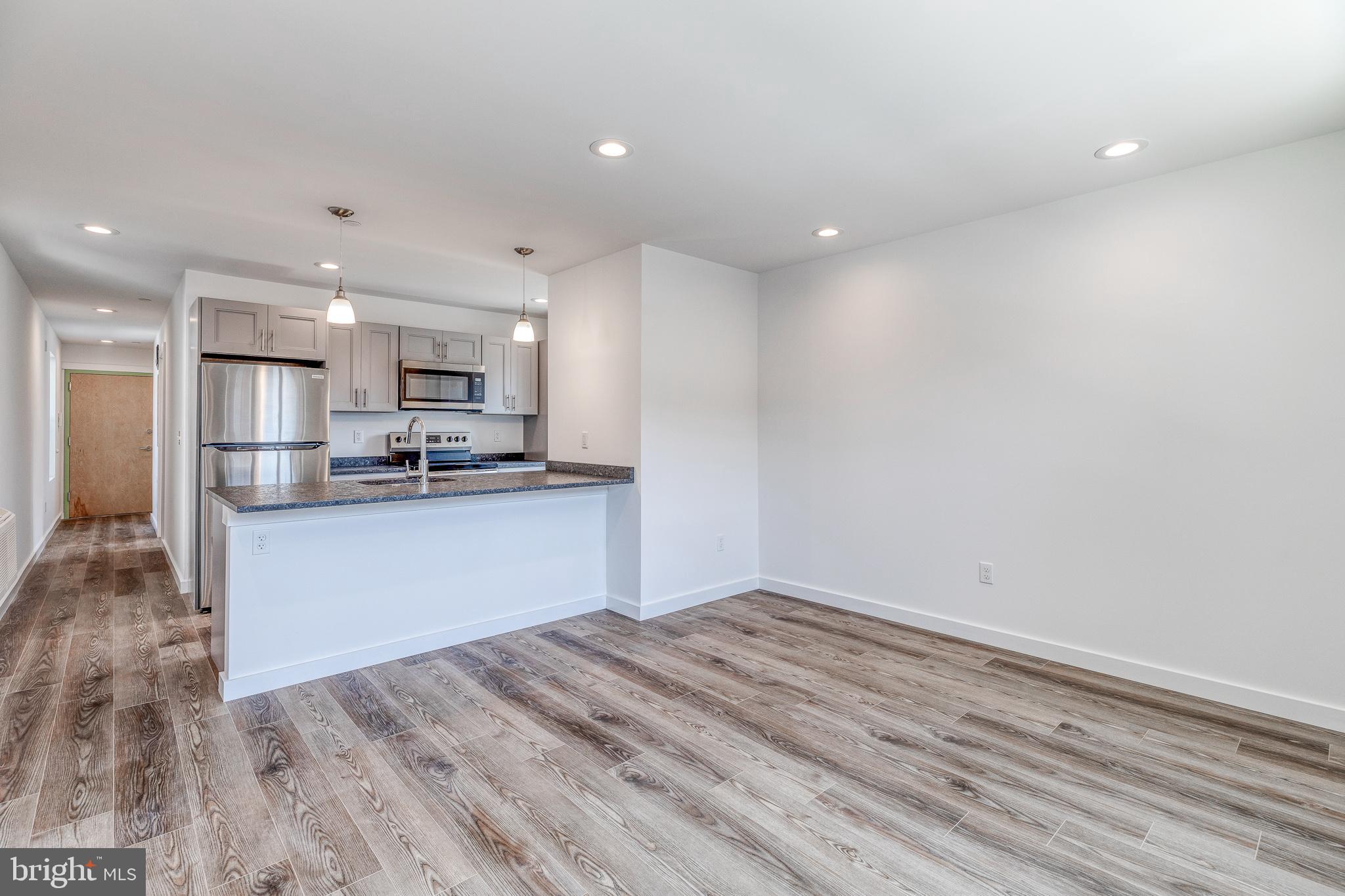 751 North 43rd Street, Unit 302 Philadelphia, PA 19104 - Photo 7 of 17 a kitchen with a refrigerator and a stove top oven