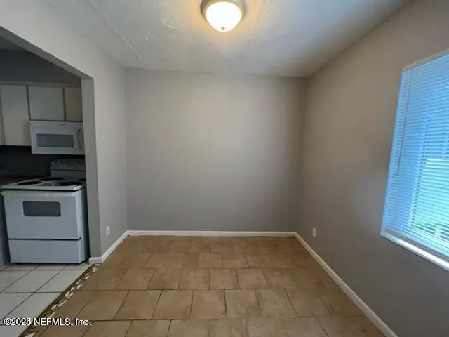 a view of a utility room with closet cabinets and a window