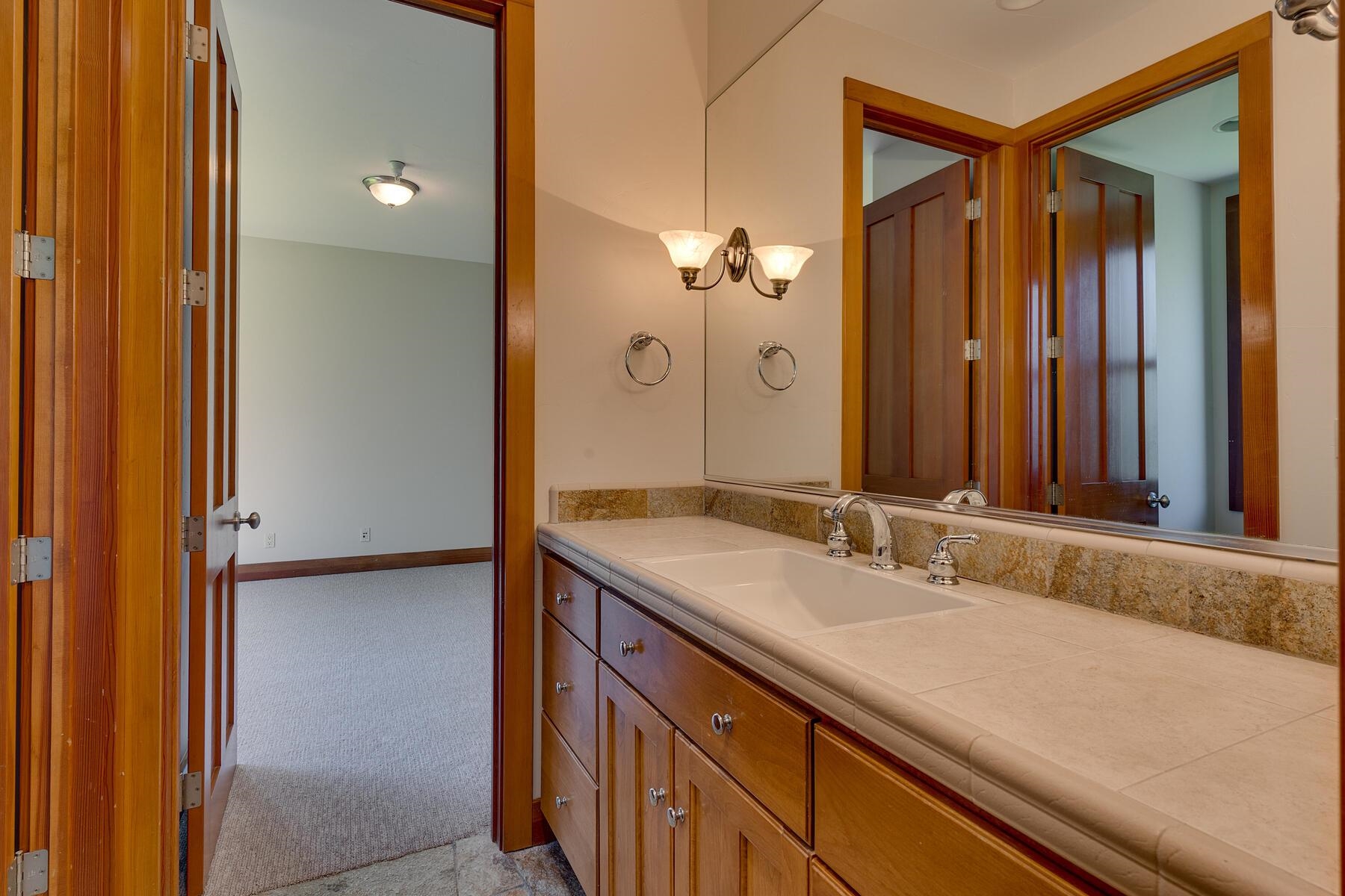 11939 Dove Terrace Truckee, CA 96161 - Photo 19 of 28 a bathroom with a granite countertop sink and a mirror