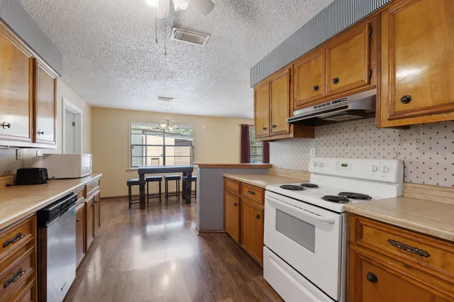a kitchen with stainless steel appliances granite countertop a stove a sink and a microwave