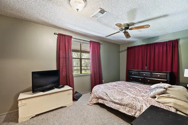 a bedroom with a bed and a television