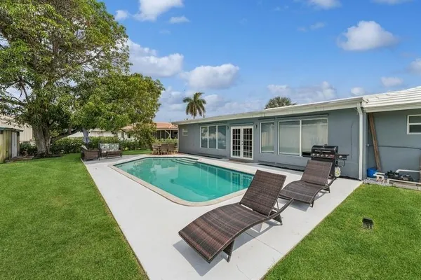 a view of a backyard with furniture and garden