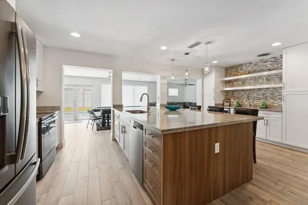 a kitchen with stainless steel appliances granite countertop lots of counter top space and cabinets