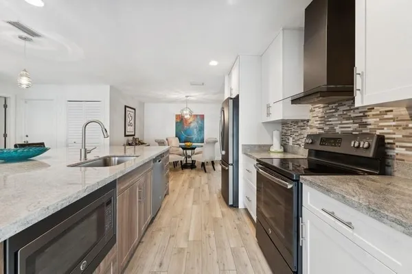 a kitchen with stainless steel appliances granite countertop a sink stove and refrigerator