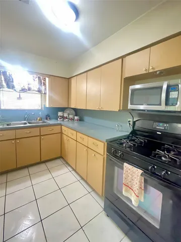 a kitchen with a stove a sink and a microwave