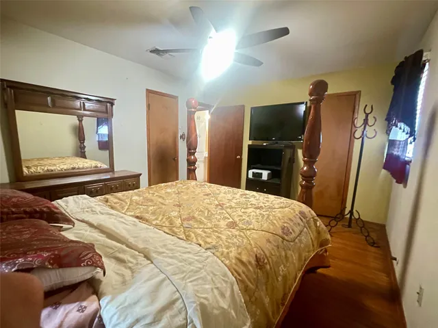 a bedroom with a bed and a flat tv screen on dresser