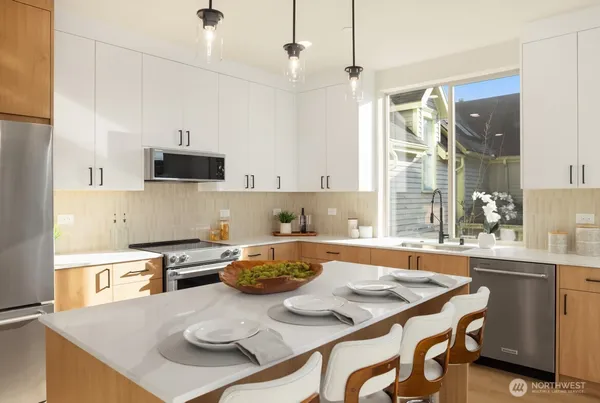 a kitchen with stainless steel appliances kitchen island granite countertop a sink a stove and a refrigerator