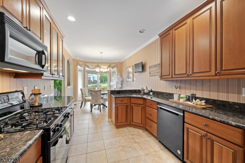26 Chestnut Court Cedar Grove, NJ 07009 - Photo 13 of 43 a kitchen with stainless steel appliances granite countertop a stove top oven a sink dishwasher and cabinets with wooden floor