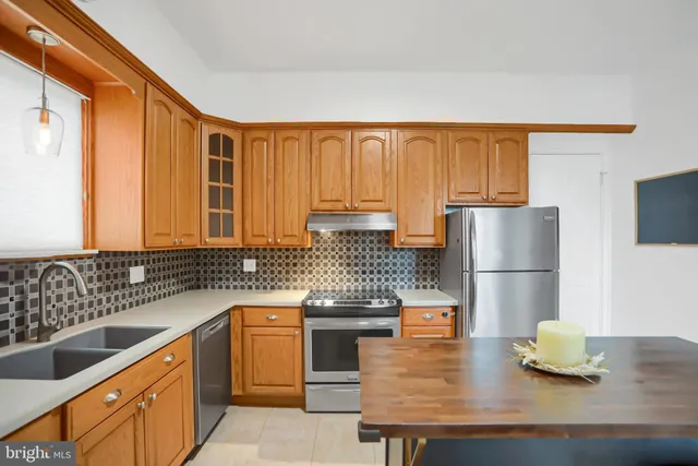 a kitchen with granite countertop a sink a stove and refrigerator
