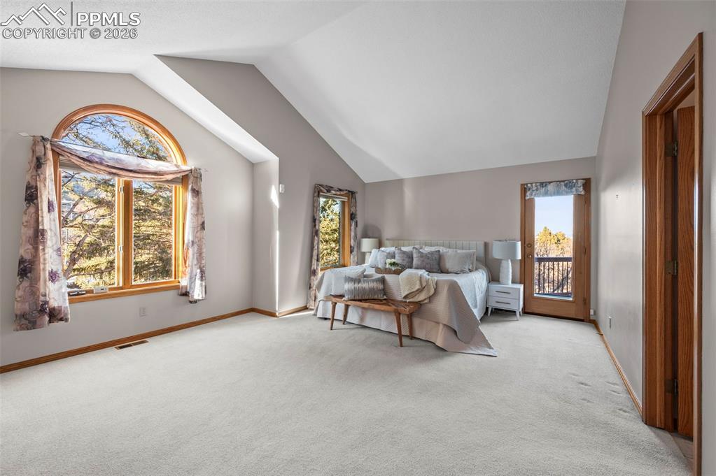735 Pollux Drive Colorado Springs, CO 80906 - Photo 21 of 50 a spacious bedroom with a balcony a bed and a large window