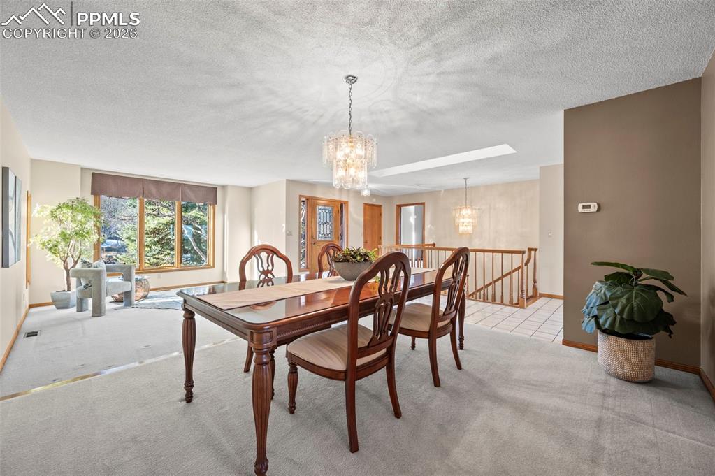 735 Pollux Drive Colorado Springs, CO 80906 - Photo 6 of 50 a dining room with furniture potted plants and a chandelier