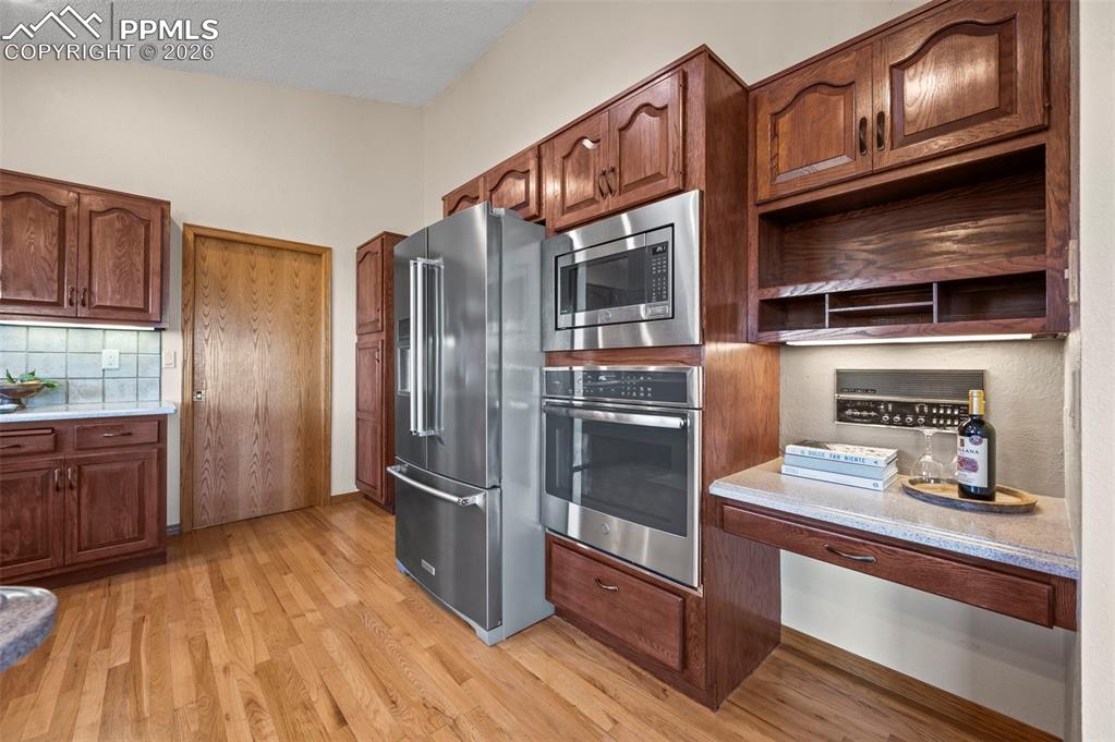 735 Pollux Drive Colorado Springs, CO 80906 - Photo 9 of 50 a kitchen with granite countertop stainless steel appliances and wooden cabinets