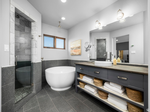22677 East Snowbird Drive, Unit 47 Helper, UT 84526 - Photo 20 of 43 Full bath with vanity, a shower stall, tile walls, a freestanding tub, and granite floors